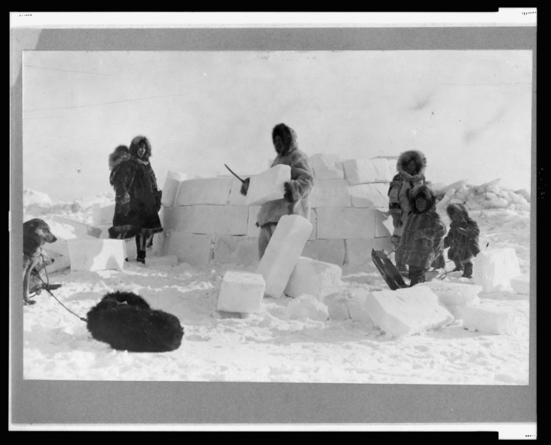 Inuit building an igloo out of "skare"