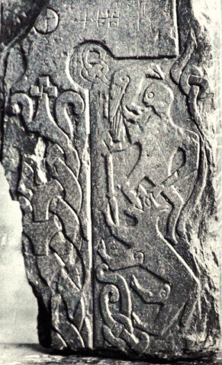 Odin with his raven, bitten by Fenrir, on Thorwald's Cross of the Manx runestones